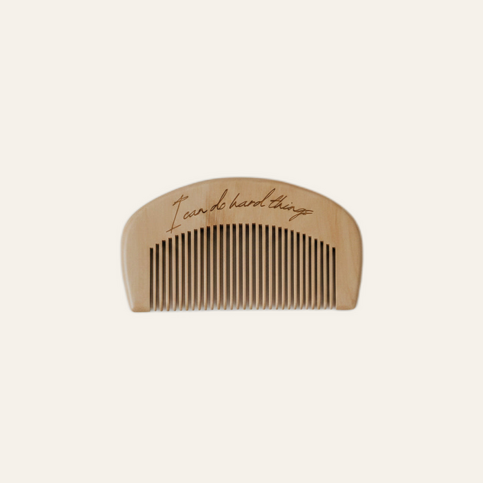 engraved wooden labor comb on warm beige